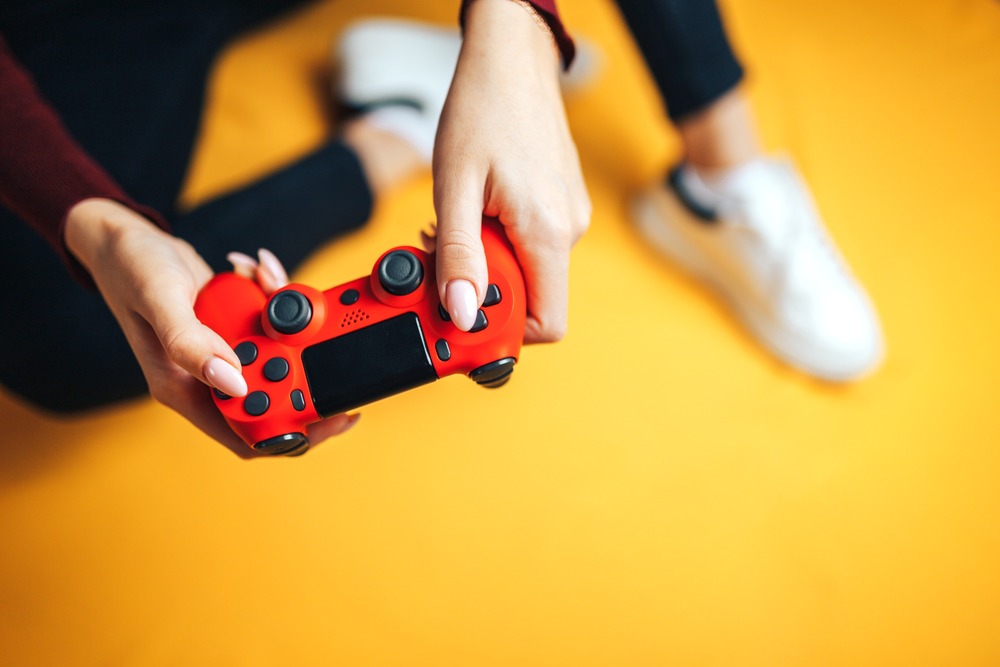manos de mujer sujetando mando de consola